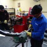 H-E Parts employee attaching hose fitting to aeroquip hose